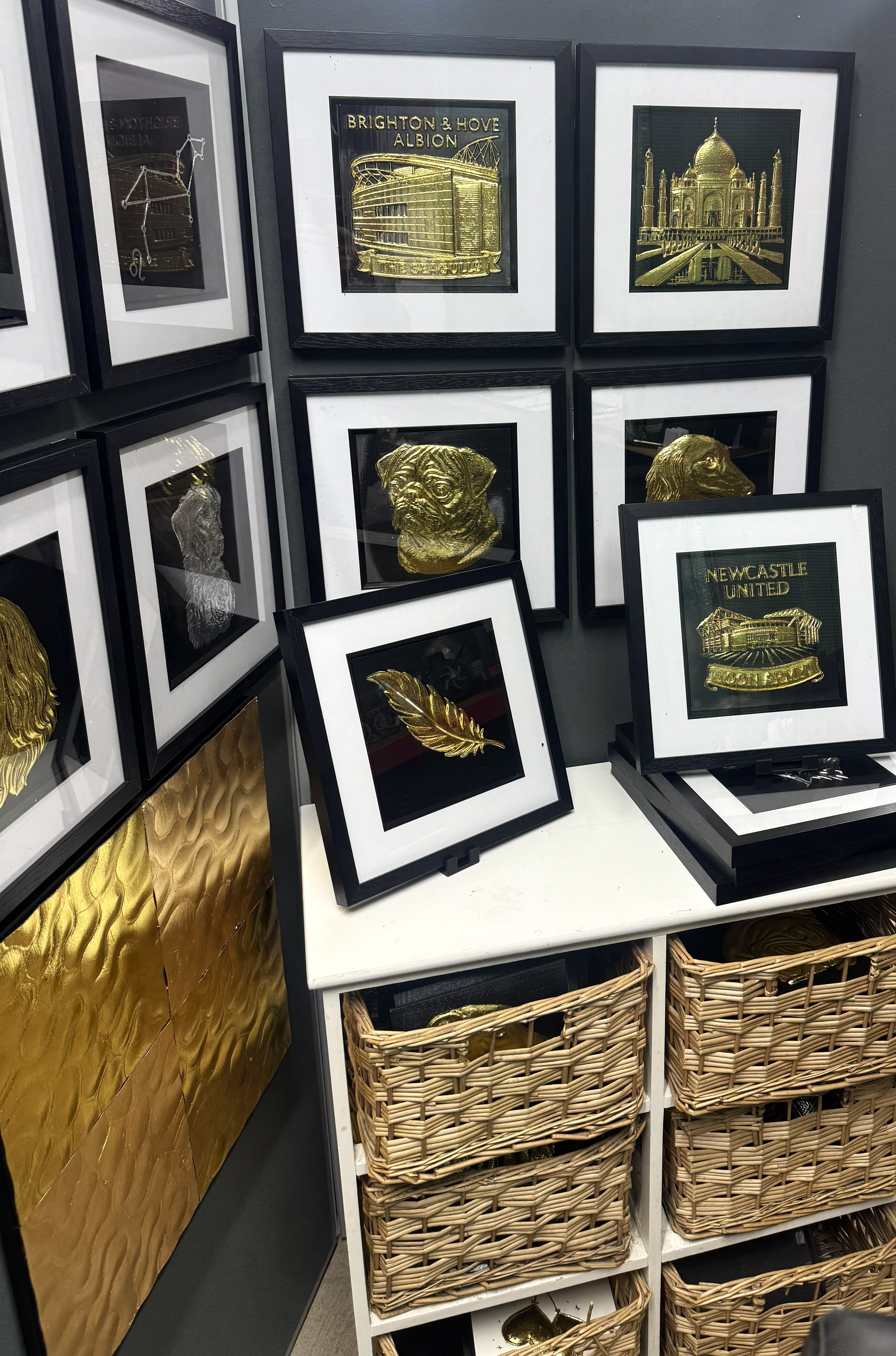 Framed 3D wall art collection displayed in JP Designs studio showing football stadiums and pet portraits