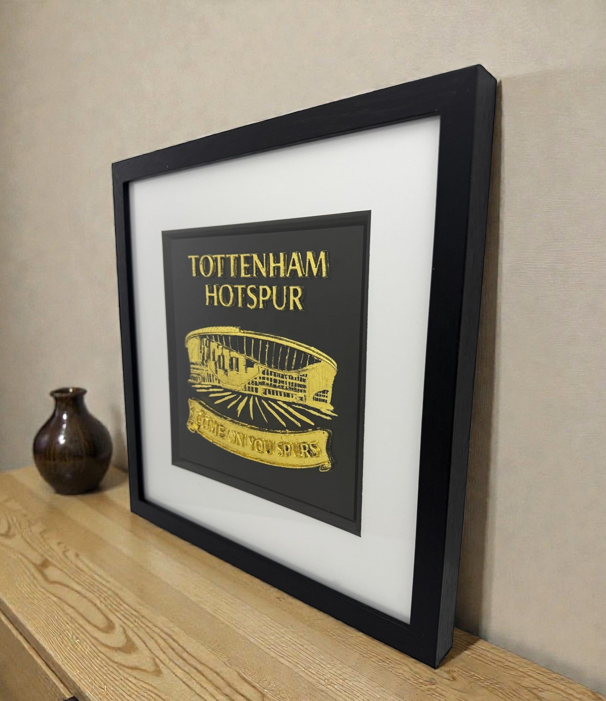 Framed Tottenham Hotspur stadium wall art on wooden surface, gold leaf 3D relief with TOTTENHAM HOTSPUR text and Come On You Spurs banner