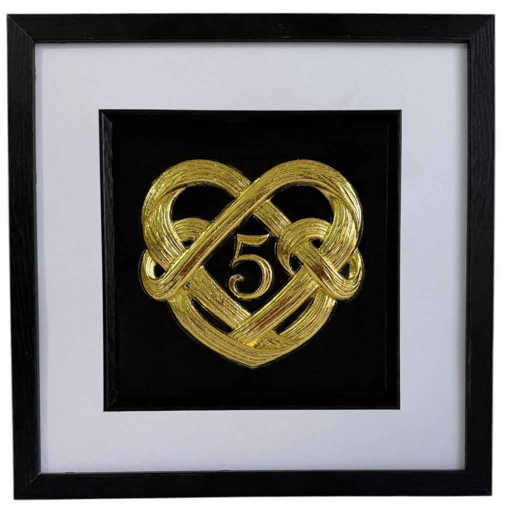 Gold framed 5th wedding anniversary heart knot artwork with central number 5, black box frame, white mount, and black inner surround.