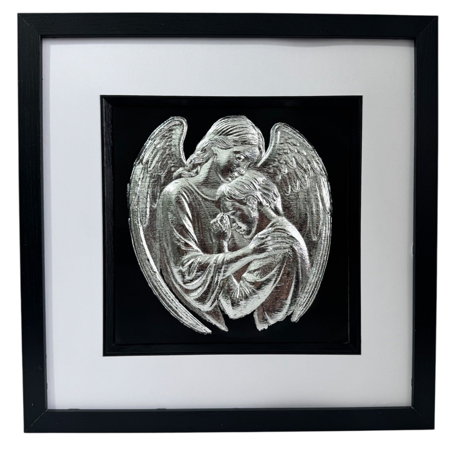 Silver leaf angel embracing a human figure framed in black wood with white mount on a black background