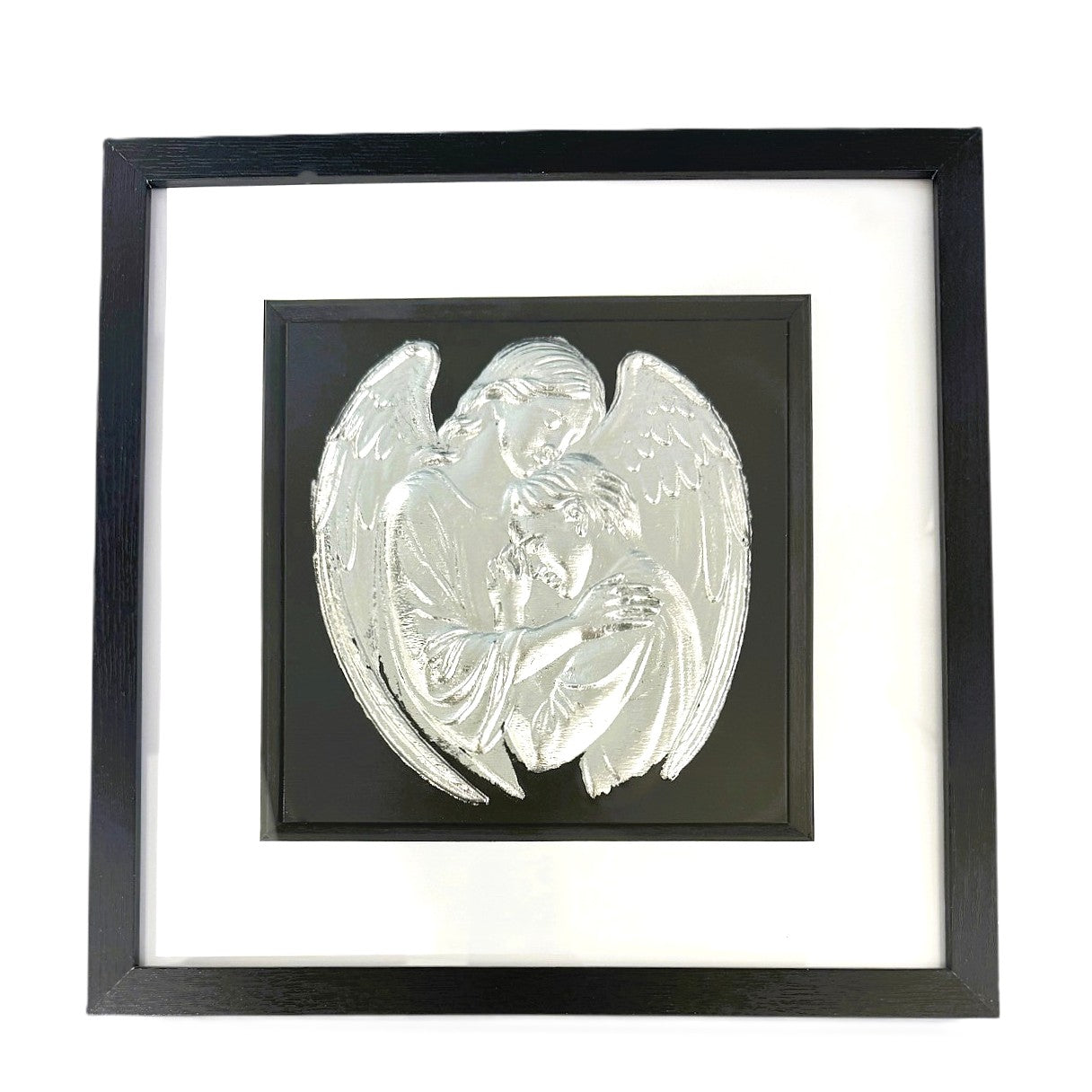 Silver leaf angel embracing a human figure framed in black wood with white mount on a black background