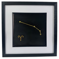 Framed Aries constellation wall art in gold leaf with star pattern and zodiac symbol, centred on a black background with white mount and black frame