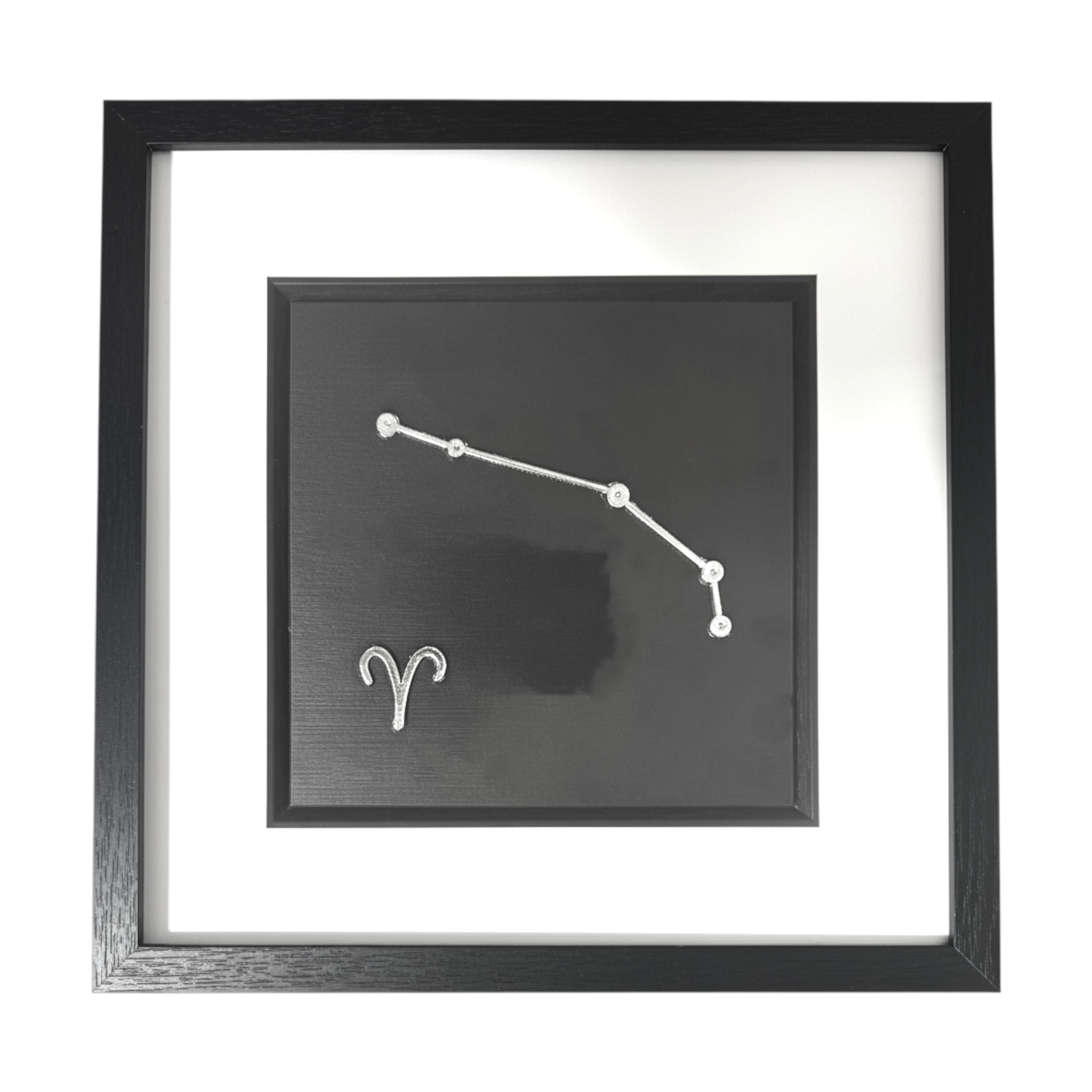 Framed Aries constellation wall art in silver leaf with star pattern and zodiac symbol, centred on a black background with white mount and black frame