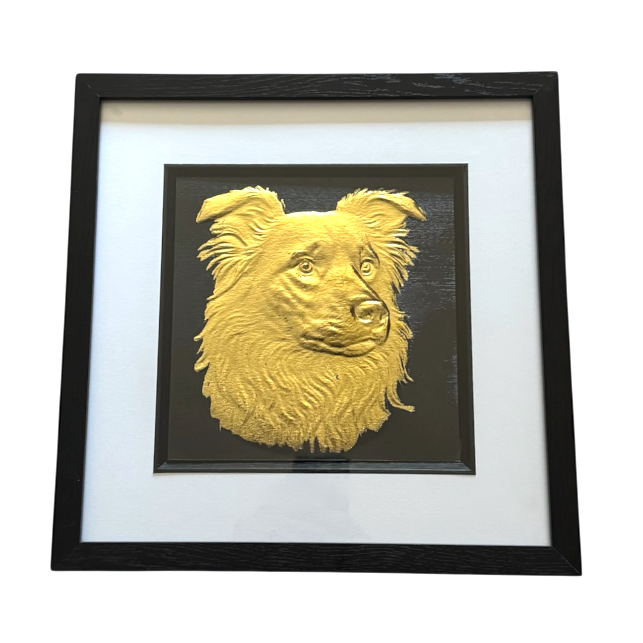 Framed border collie wall art in gold leaf relief, centred on a black background with white mount and black wooden frame