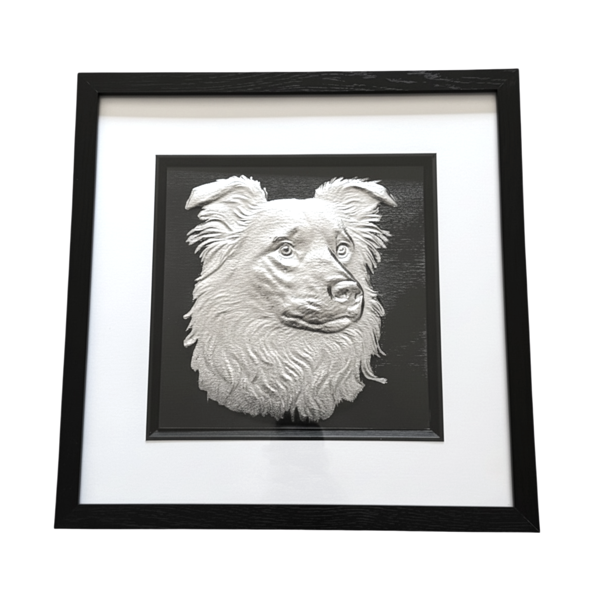 Framed border collie wall art in silver leaf relief, centred on a black background with white mount and black wooden frame
