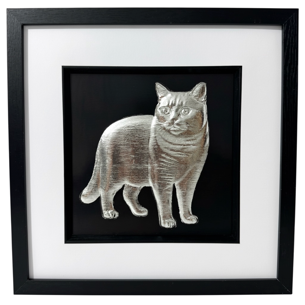 British Shorthair cat wall art in silver leaf, realistic 3D relief portrait on black background, black frame with white mount and glass front, front view