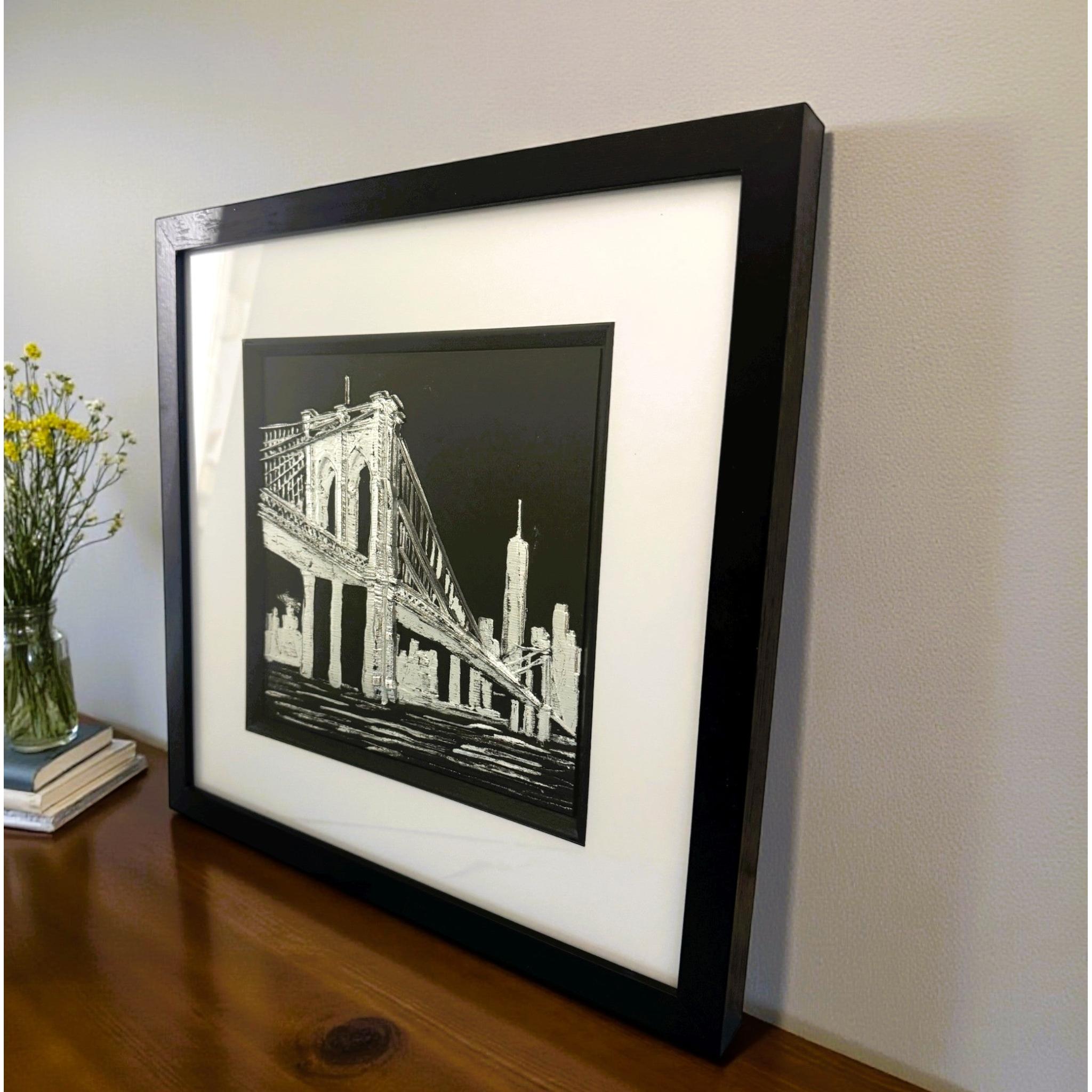 Angled view of Brooklyn Bridge wall art displayed on a shelf