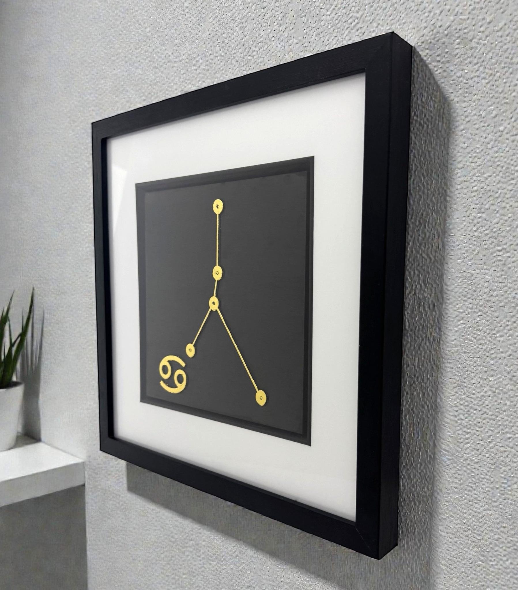 Framed Cancer constellation wall art in gold leaf mounted on a wall, shown at an angle highlighting the depth and clean presentation