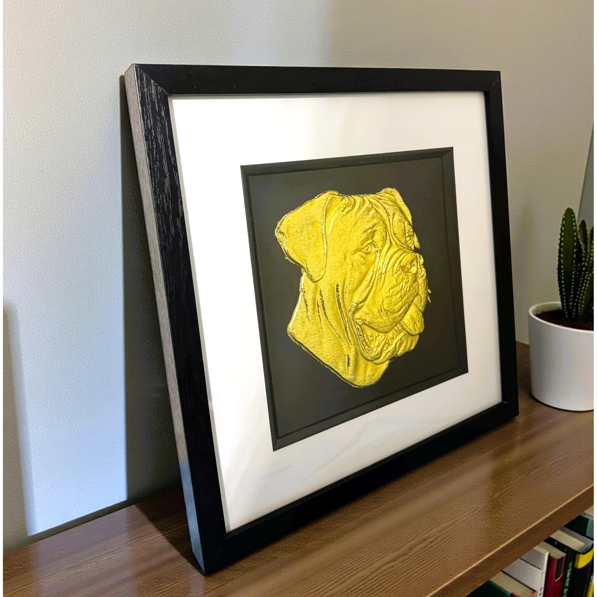 Cane Corso gold leaf wall art shown from an angled view in black wooden frame on  wooden desk