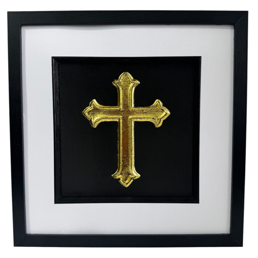 Front view of gold leaf cross wall art centred in a black wooden frame with white mount