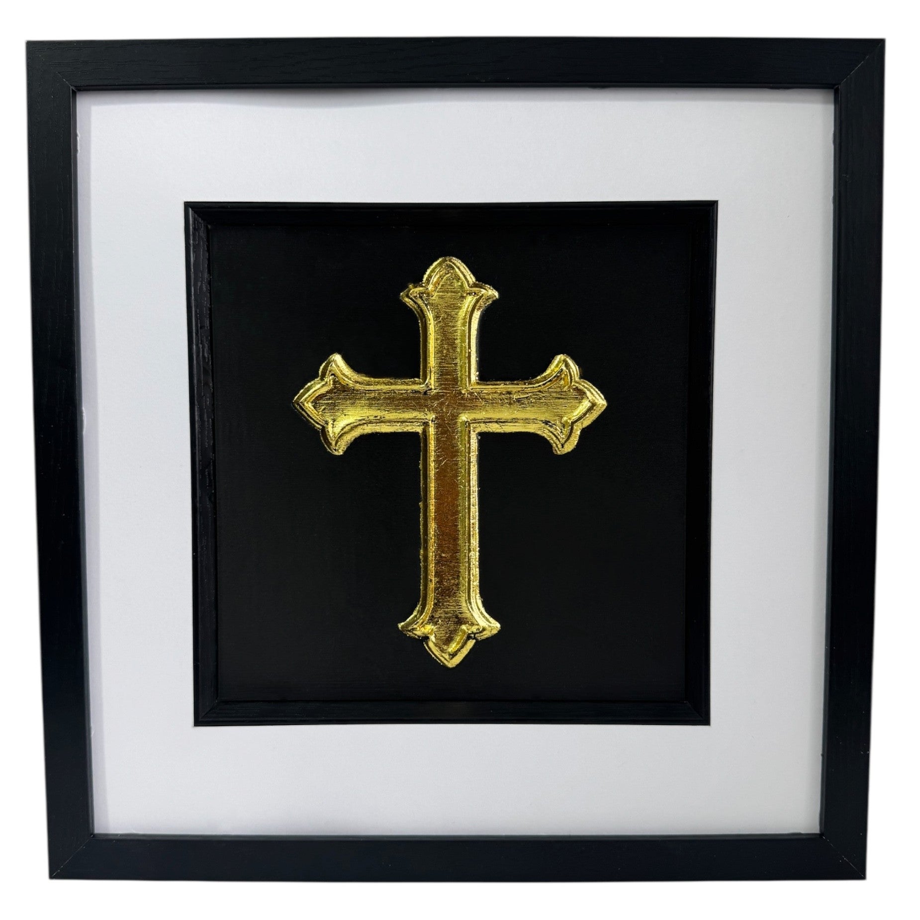 Front view of gold leaf cross wall art centred in a black wooden frame with white mount