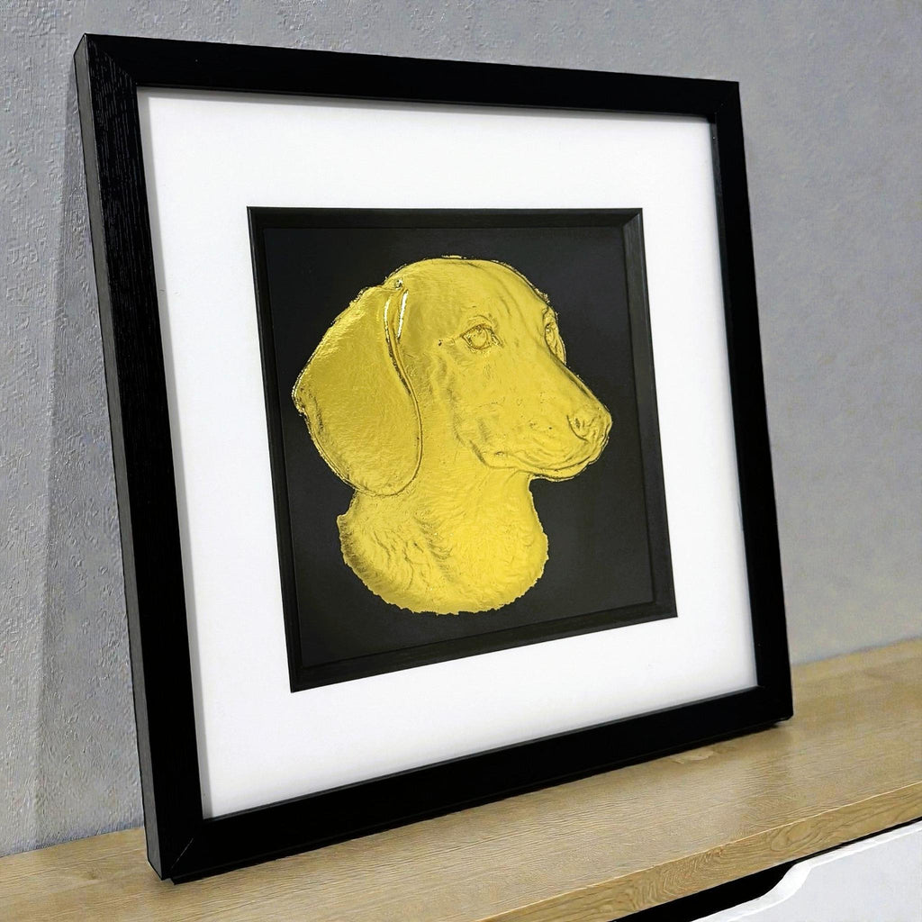 gold leaf sausage dog picture on a modern desk