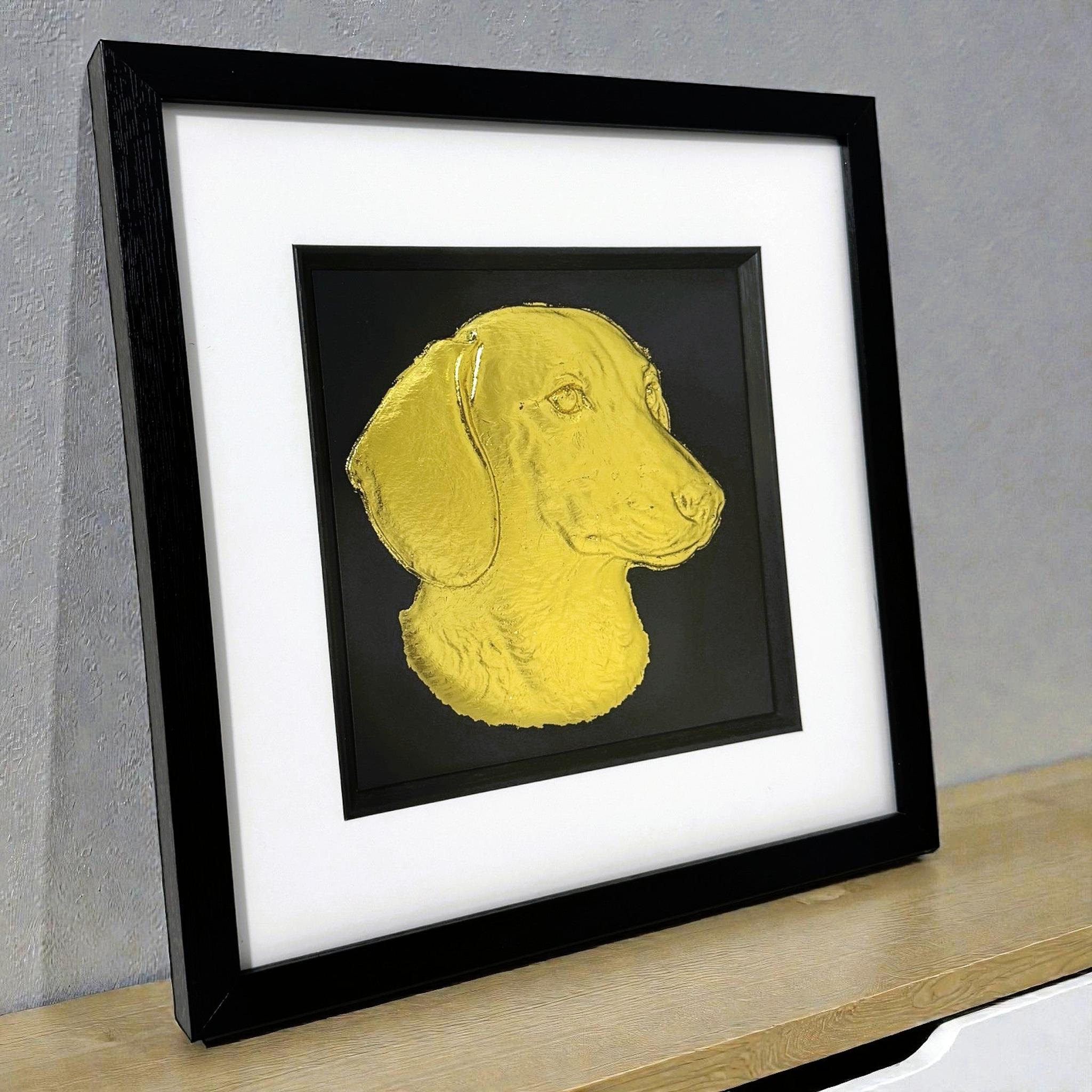 gold leaf sausage dog picture on a modern desk