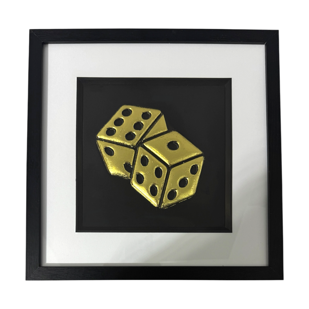 Framed dice wall art in gold leaf relief, centred on a black background with white mount and black frame
