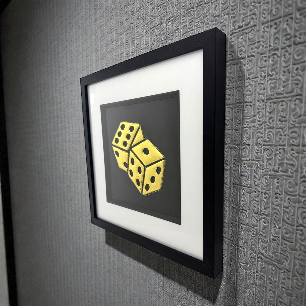 
Framed dice wall art in gold leaf relief mounted on a wall, shown at an angle highlighting depth and texture