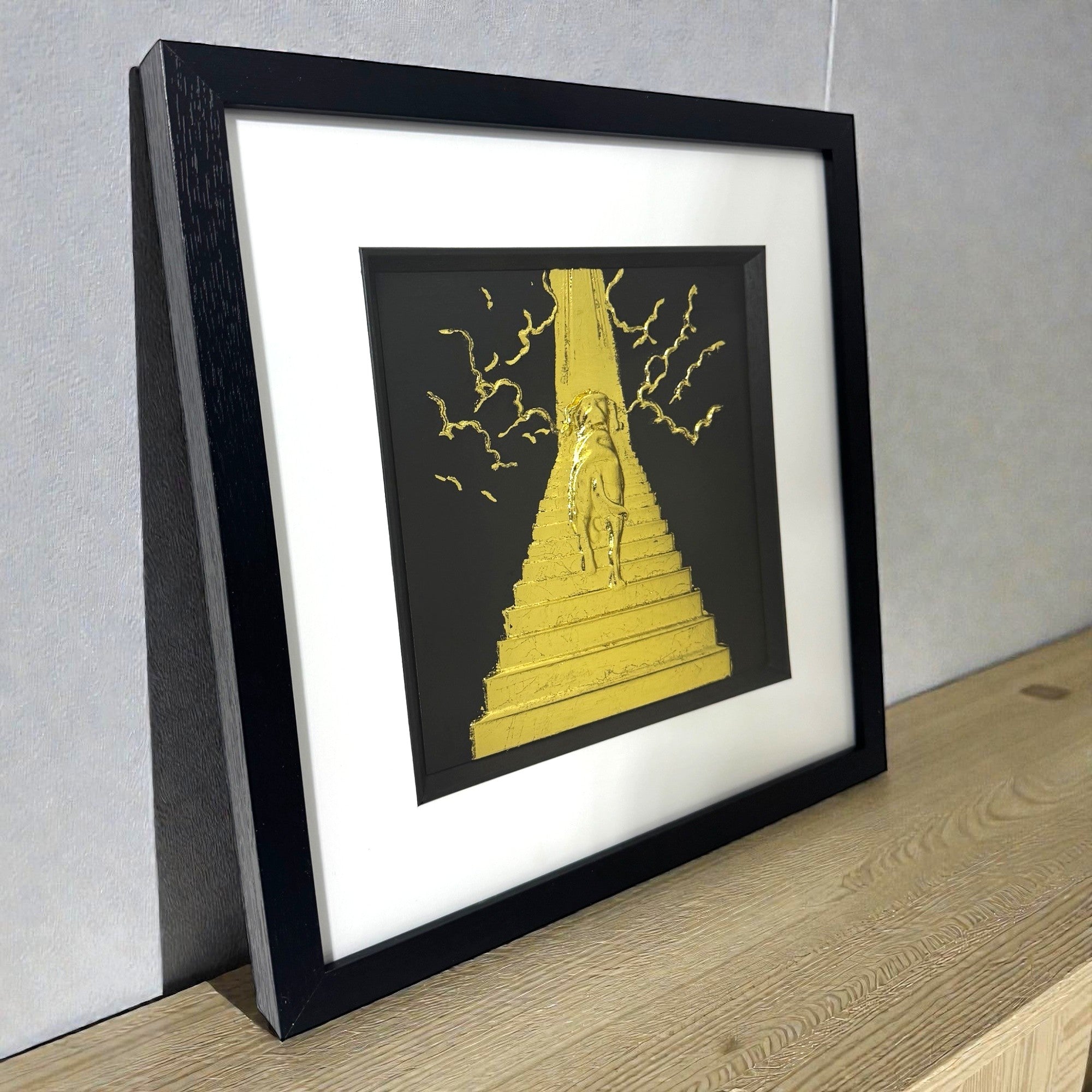 Dog Stairway to Heaven framed wall art shown on desk surface in black frame