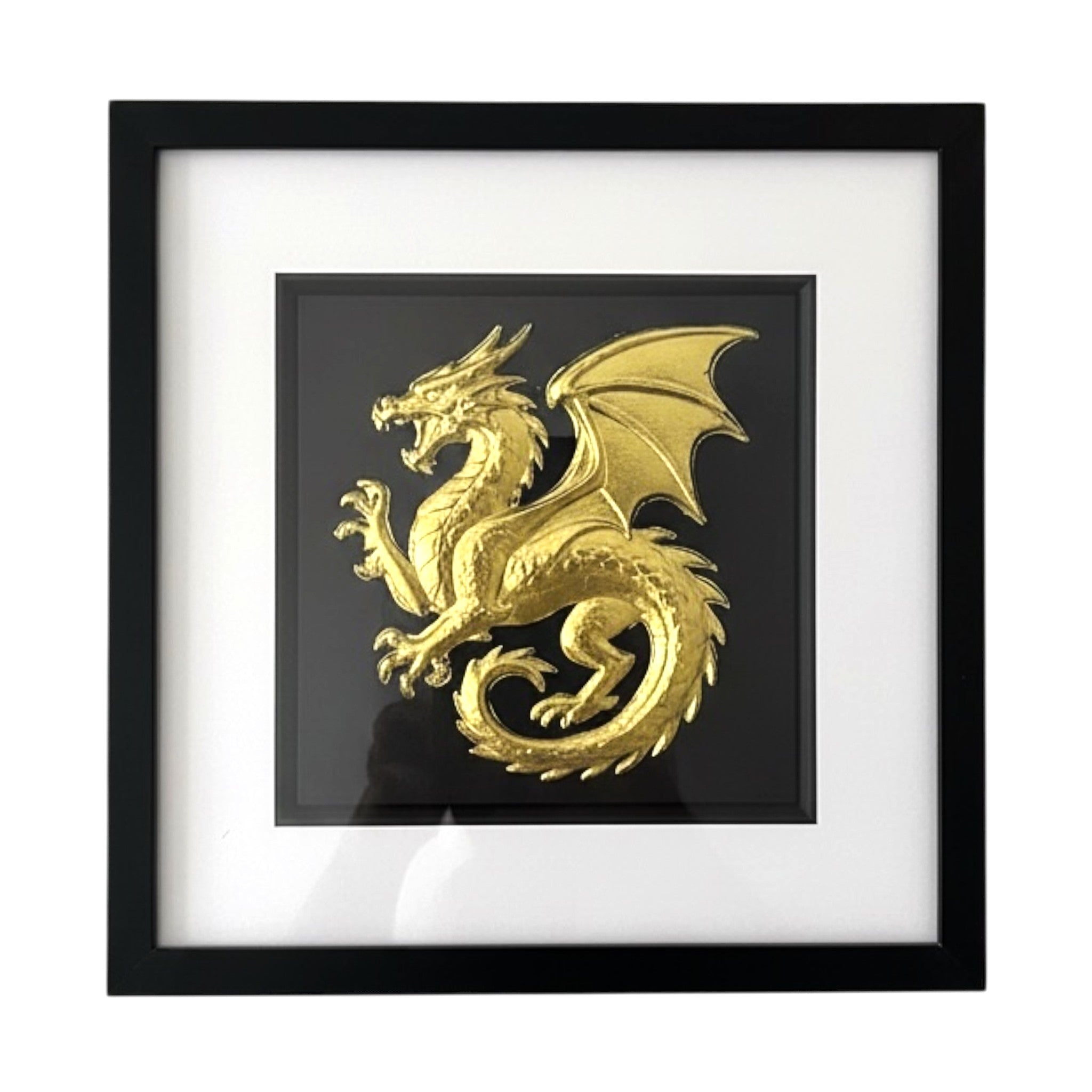 Framed dragon wall art in gold leaf relief, centred on a black background with white mount and black frame