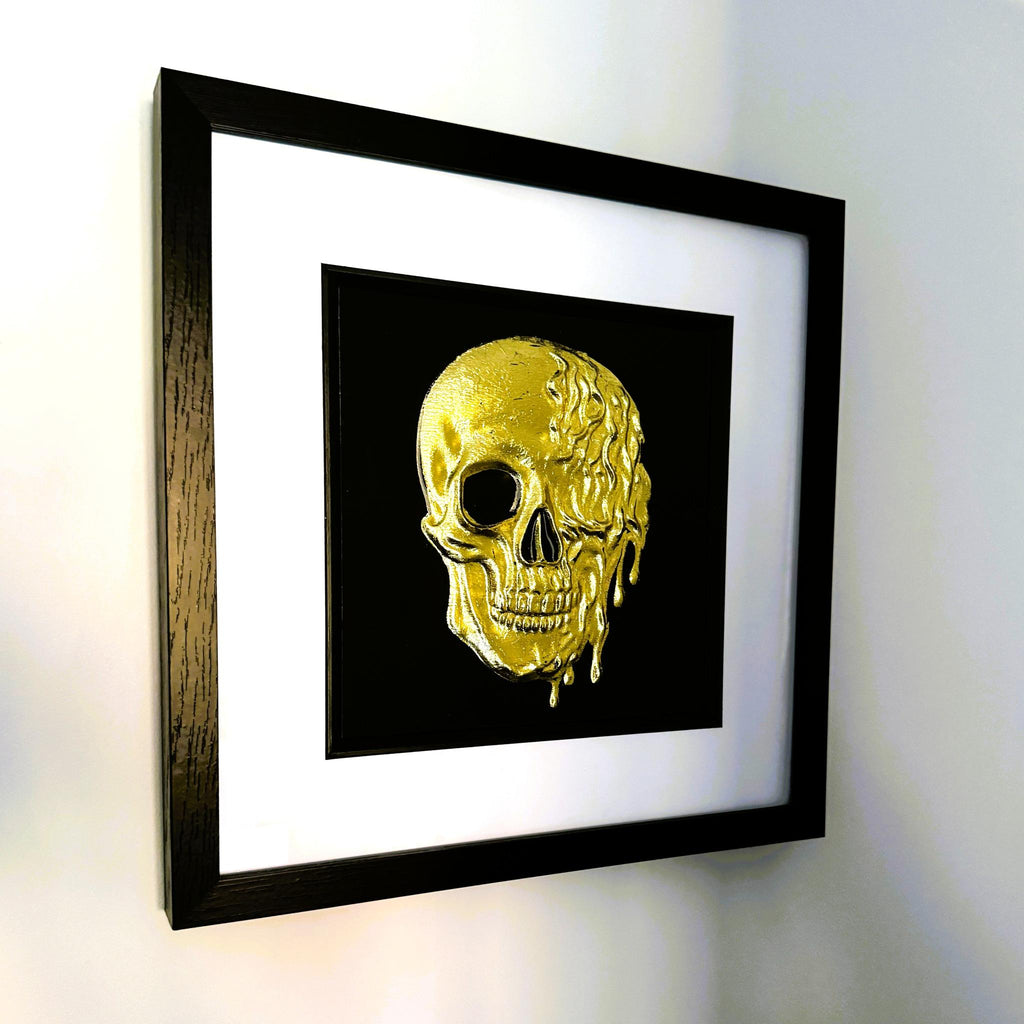Angled wall view of gold leaf molten dripping skull framed wall art