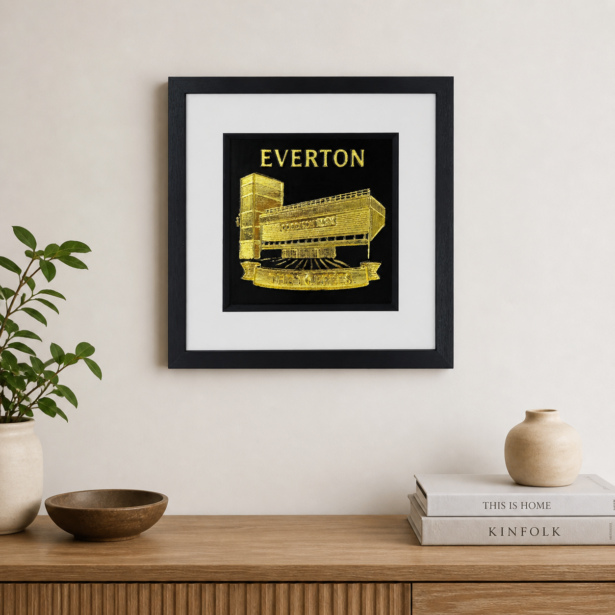 Lifestyle photo of Everton FC Goodison Park wall art displayed on a neutral wall above a wooden sideboard.