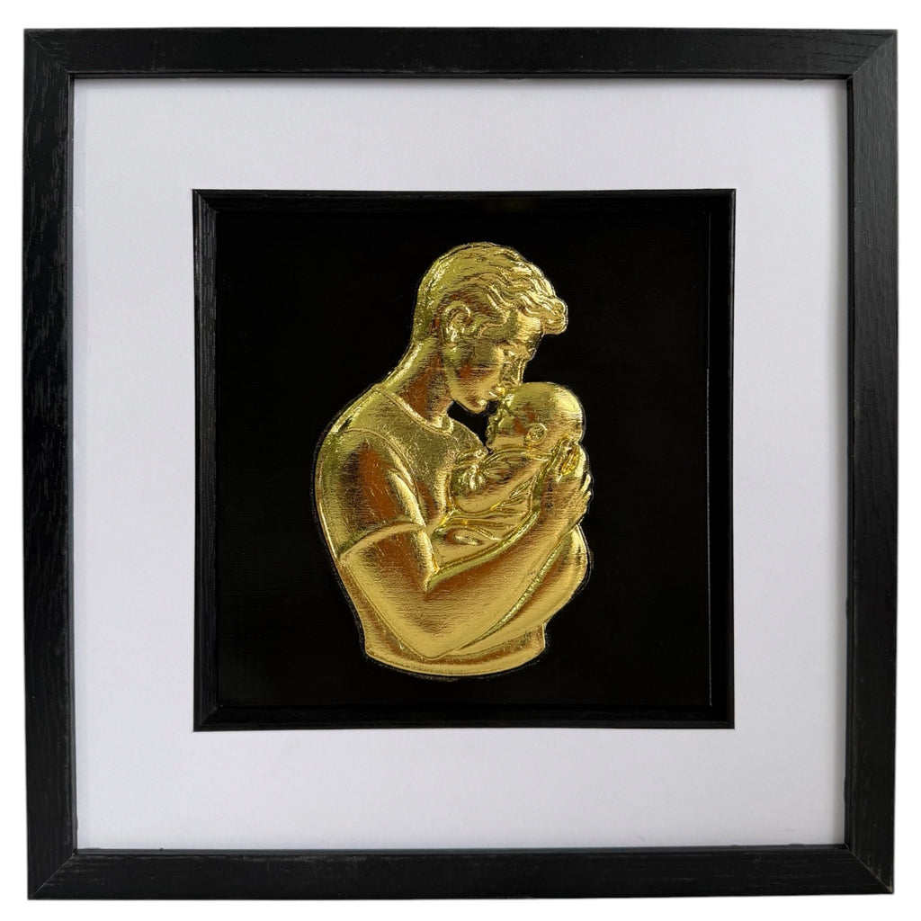 Gold father holding baby relief artwork in a black frame with white mount and black inner surround.