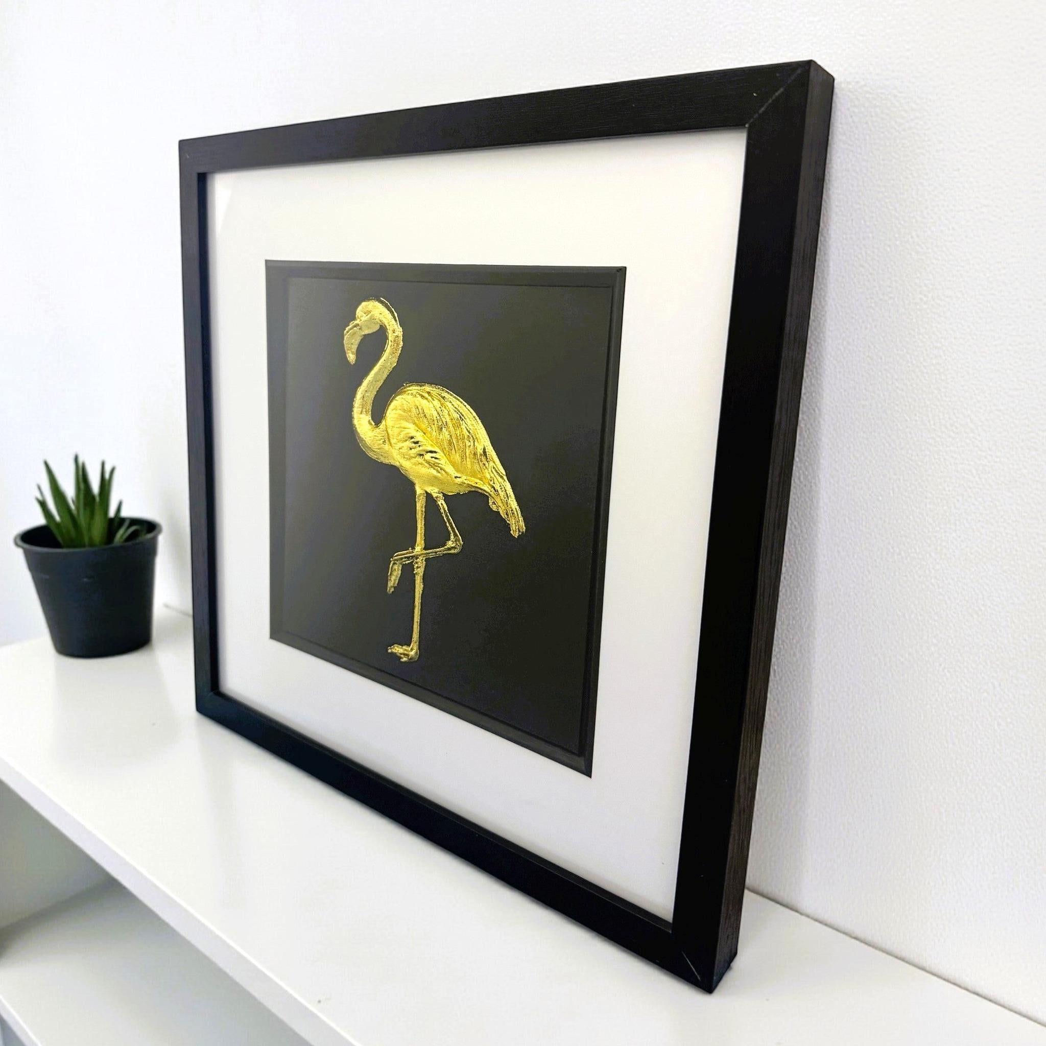 Flamingo wall art displayed on a desk in a black frame with gold leaf finish by JP Designs
