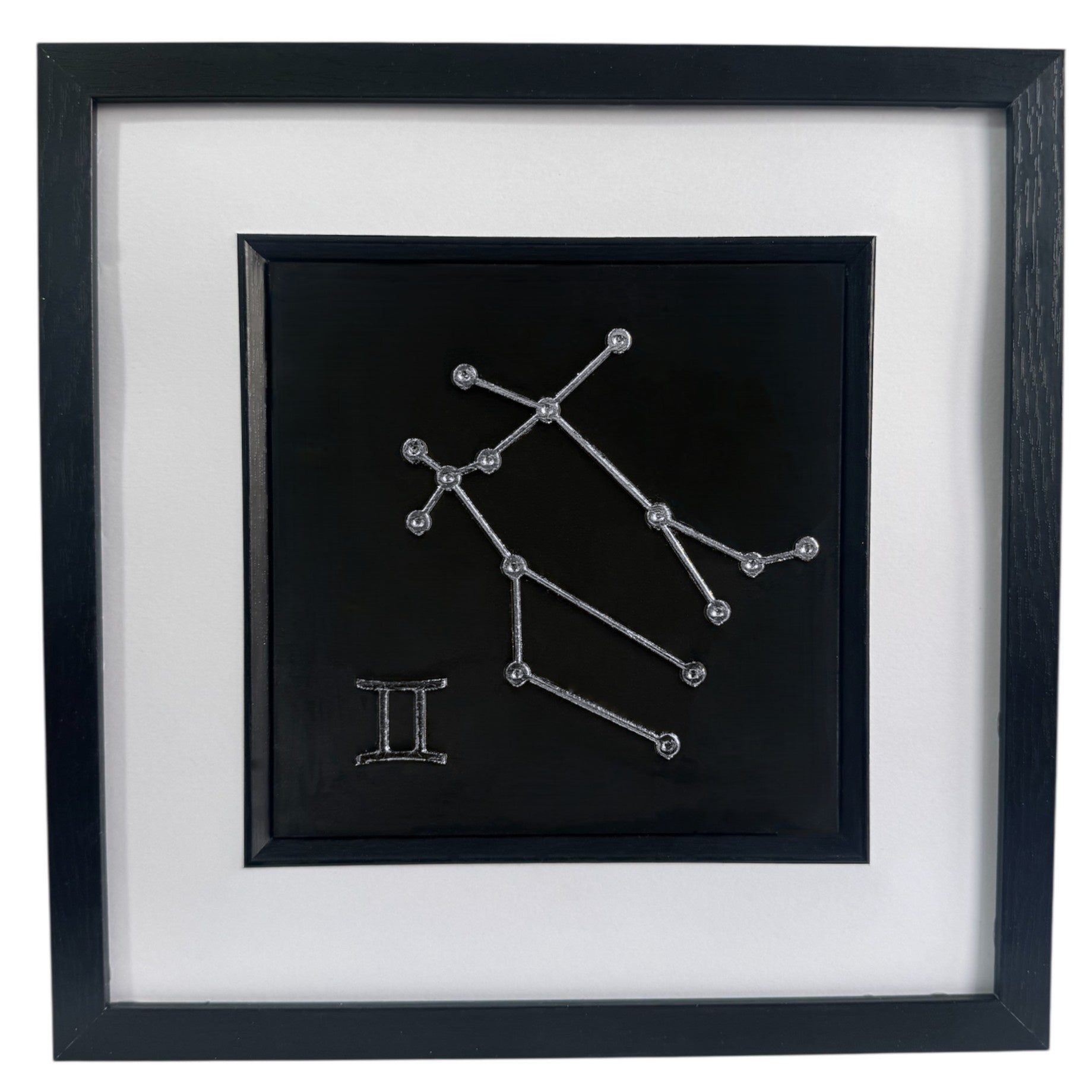 Framed Gemini constellation 3d wall art in silver leaf with star pattern and zodiac symbol gift, centred on a black background with white mount and black frame
