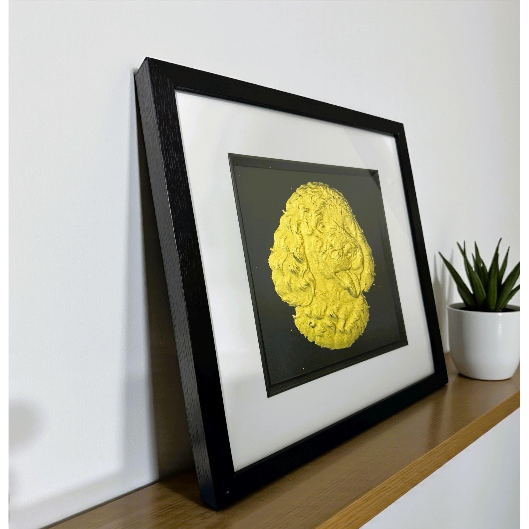 Goldendoodle framed wall art in gold leaf viewed at an angle, displayed in a black wooden frame with white mount
