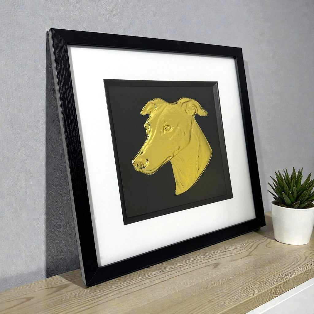 Gold leaf greyhound wall art displayed on desk in black frame