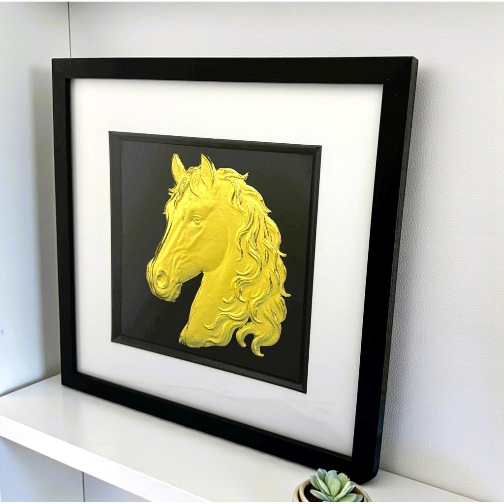 Gold horse head framed wall art displayed on a shelf