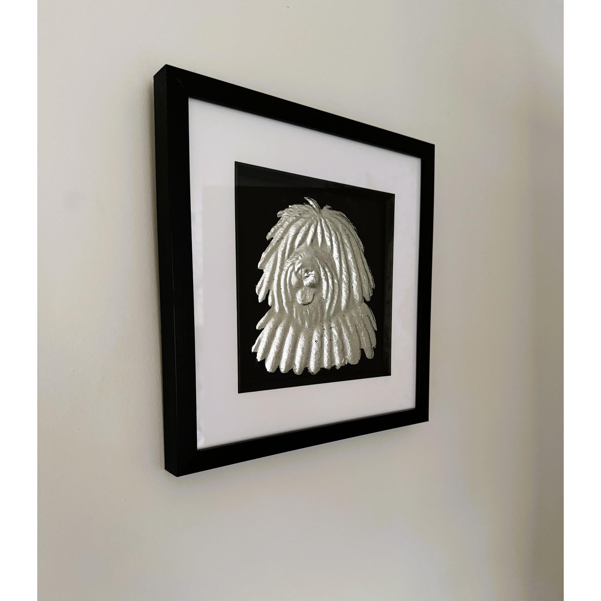 Hungarian Puli framed wall art in silver leaf mounted on a wall, with black wooden frame, white mount, and black background
