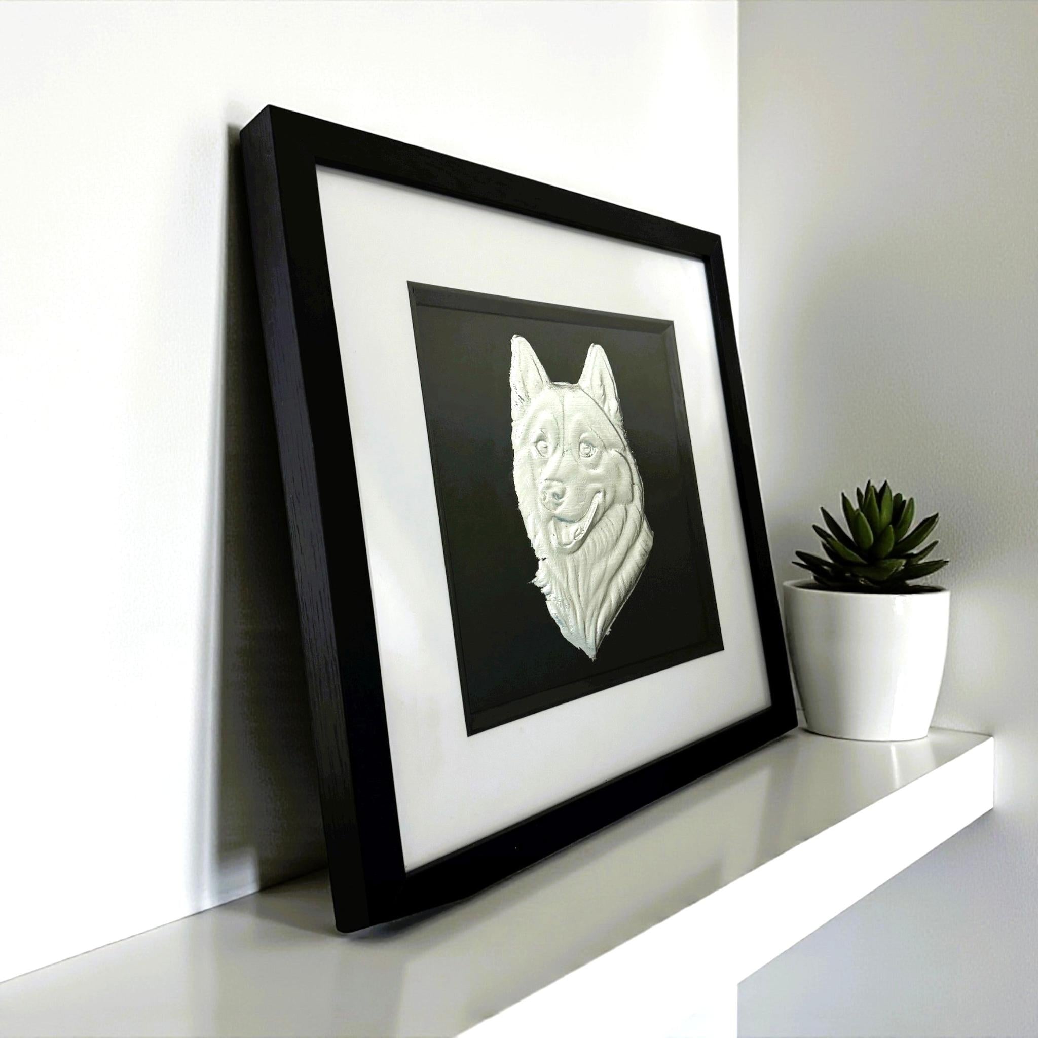 Siberian Husky framed wall art in silver leaf viewed at an angle, displayed in a black wooden frame with white mount
