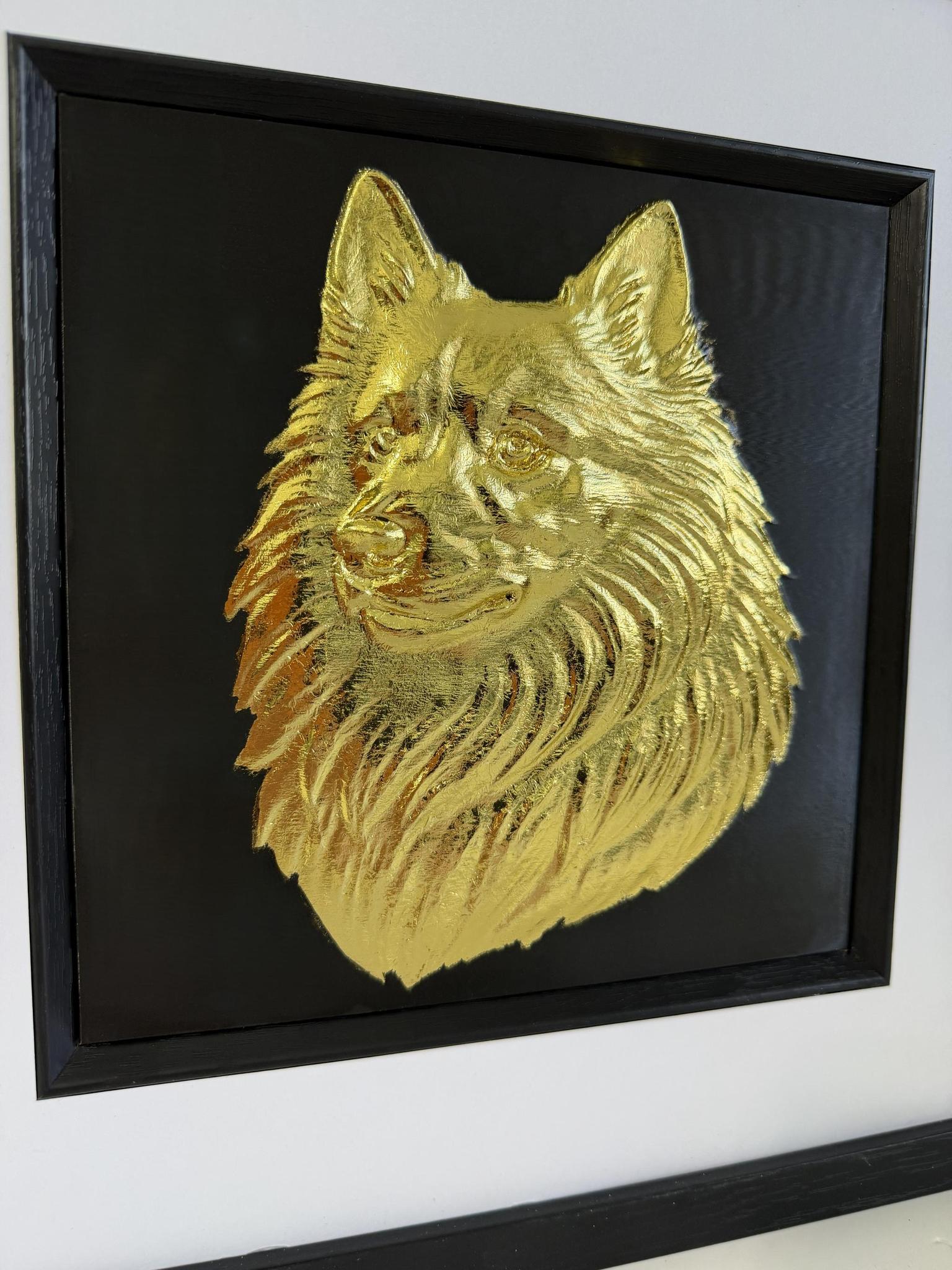 Close-up angled view of a gold Japanese Spitz relief portrait showing raised fur detail inside the black inner surround.