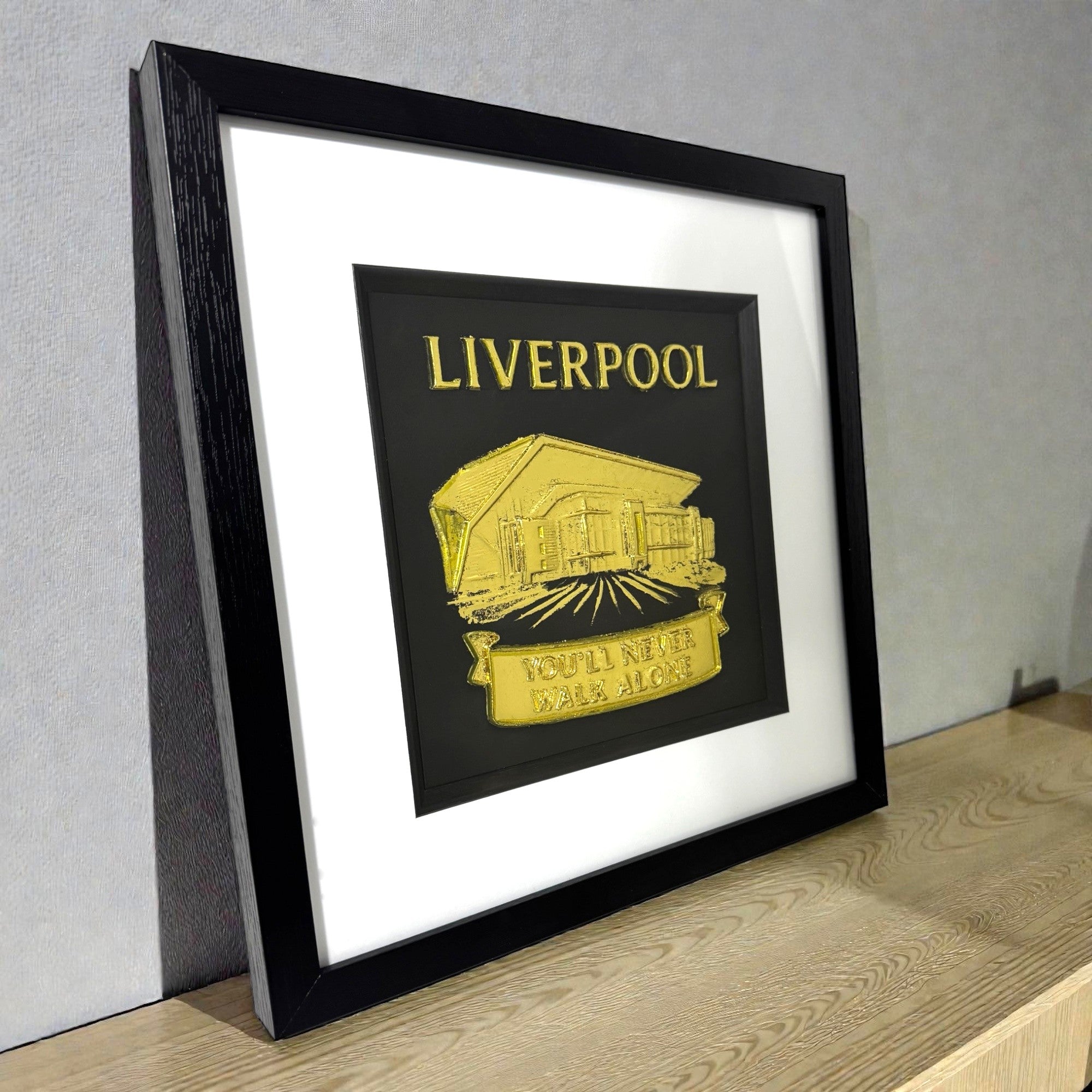 Framed Liverpool gold 3D wall art displayed on a modern wooden shelf.