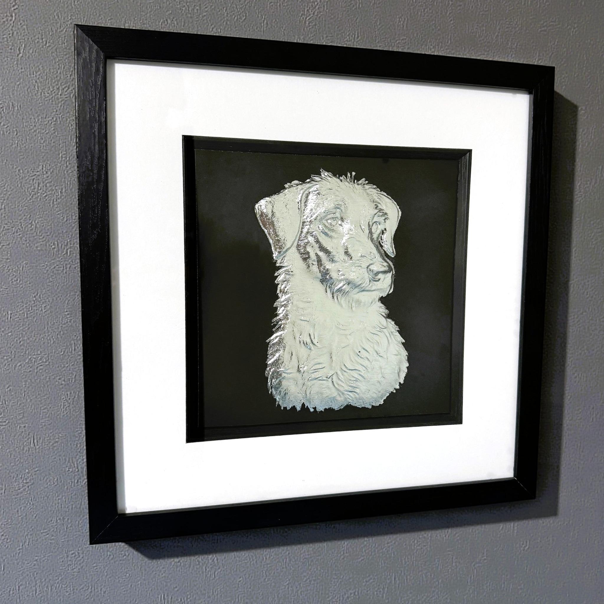 Lurcher framed wall art in silver leaf shown mounted on a wall at a slight angle with black frame and white mount