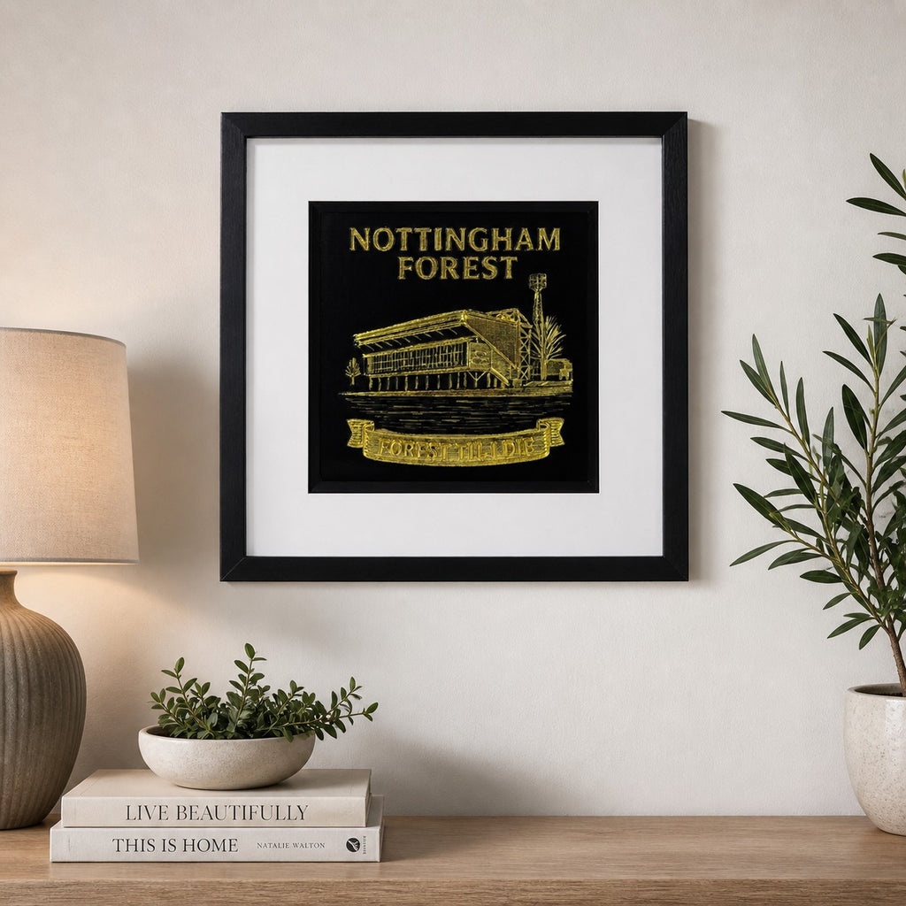 Lifestyle photo of Nottingham Forest FC wall art displayed on a neutral wall above a wooden sideboard with home decor.