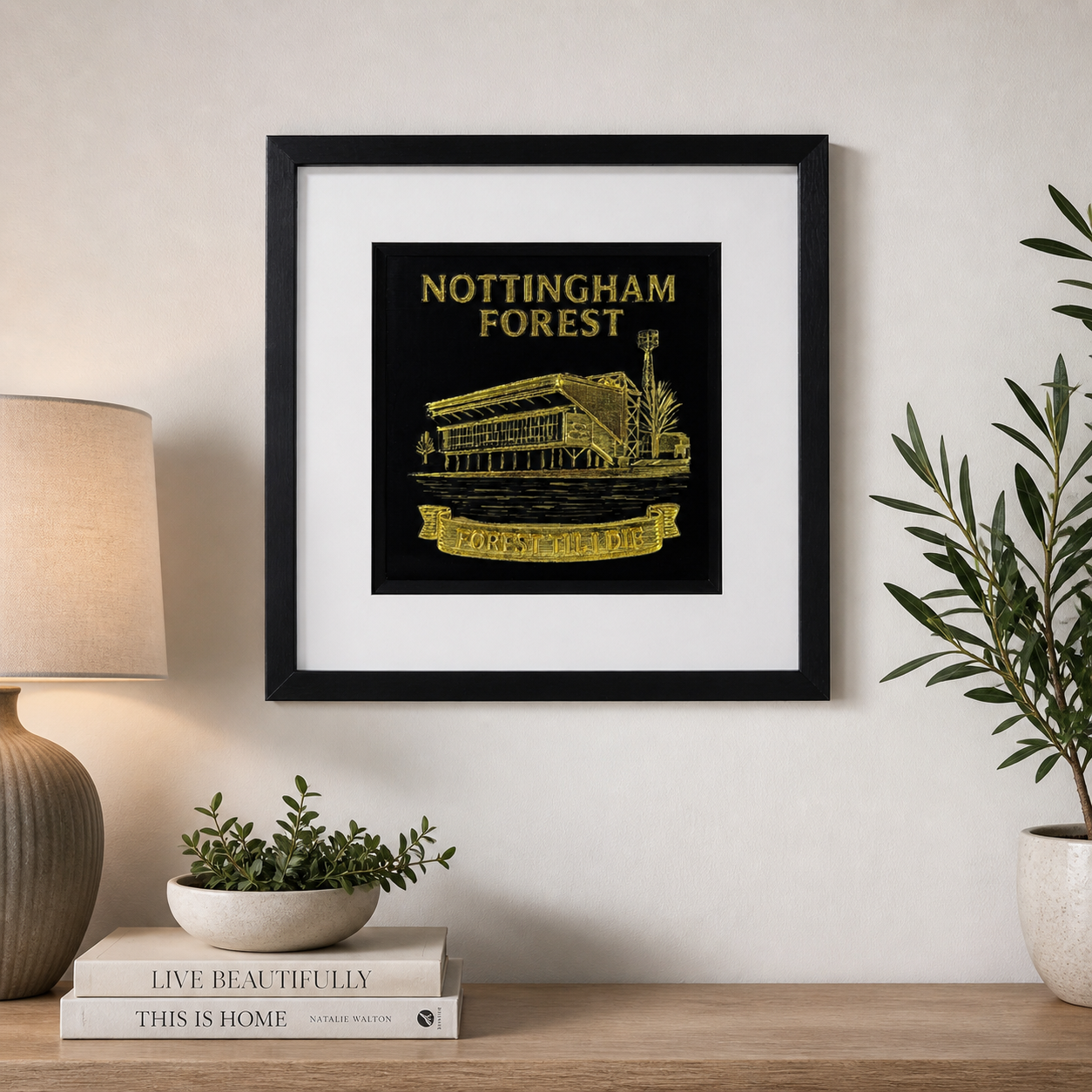 Lifestyle photo of Nottingham Forest FC wall art displayed on a neutral wall above a wooden sideboard with home decor.