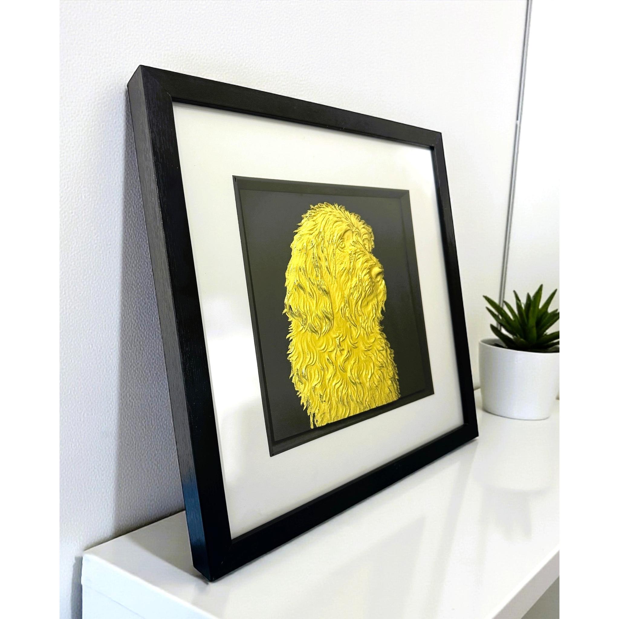 Otterhound gold leaf wall art photographed at an angle on a shelf with black frame white mount and black background