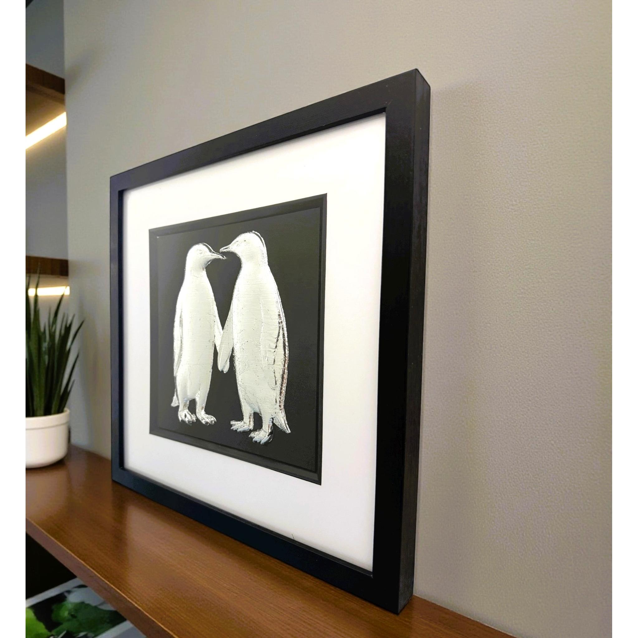 Silver penguin couple wall art displayed in a modern interior setting