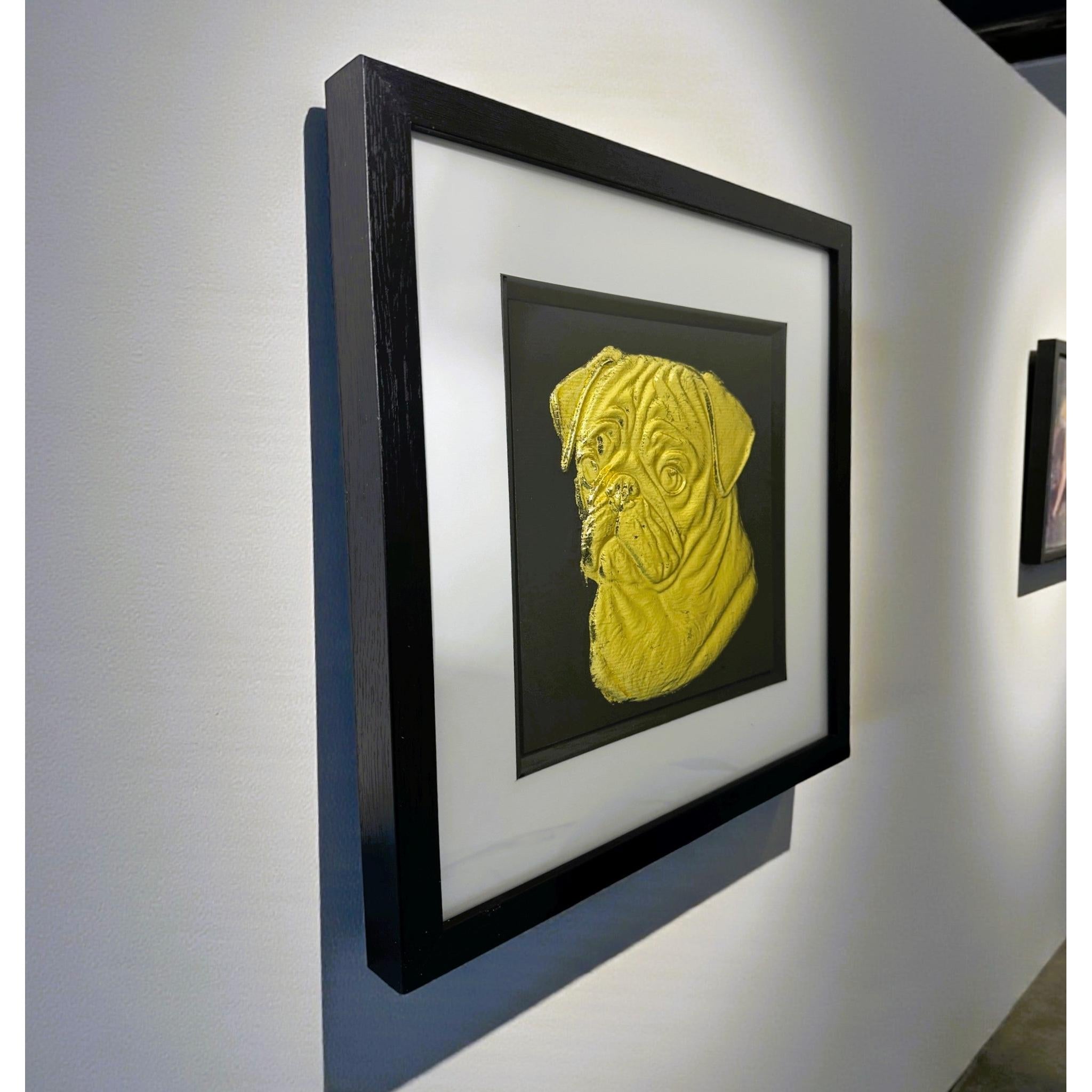 Pug gold leaf framed wall art shown mounted on a wall at a slight angle with black frame and white mount