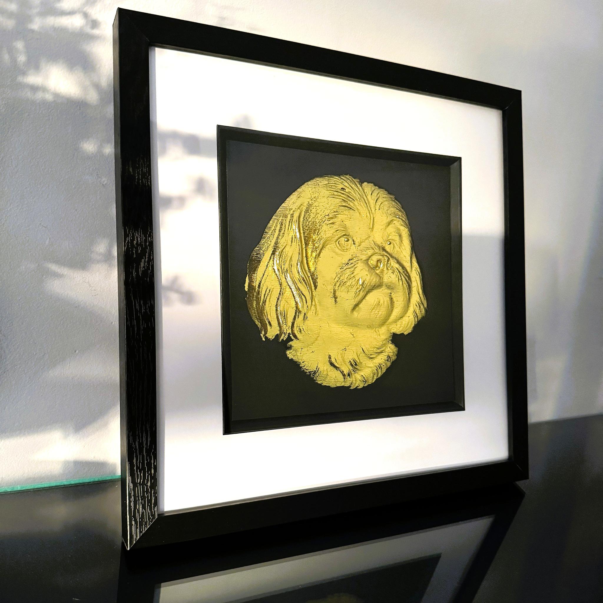 Shih Tzu gold leaf wall art photographed at an angle on a reflective surface with black frame and white mount