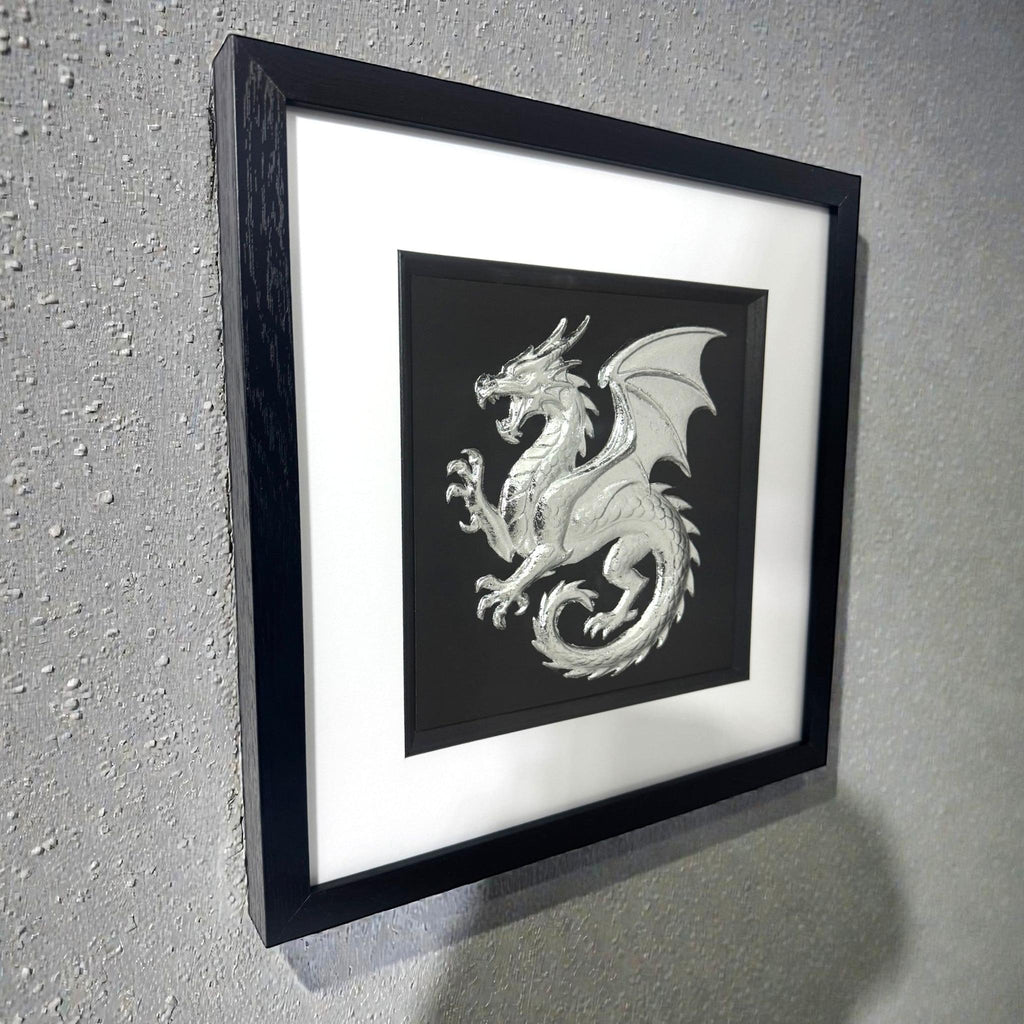 Silver dragon picture silver leaf in frame mounted to a light grey wall