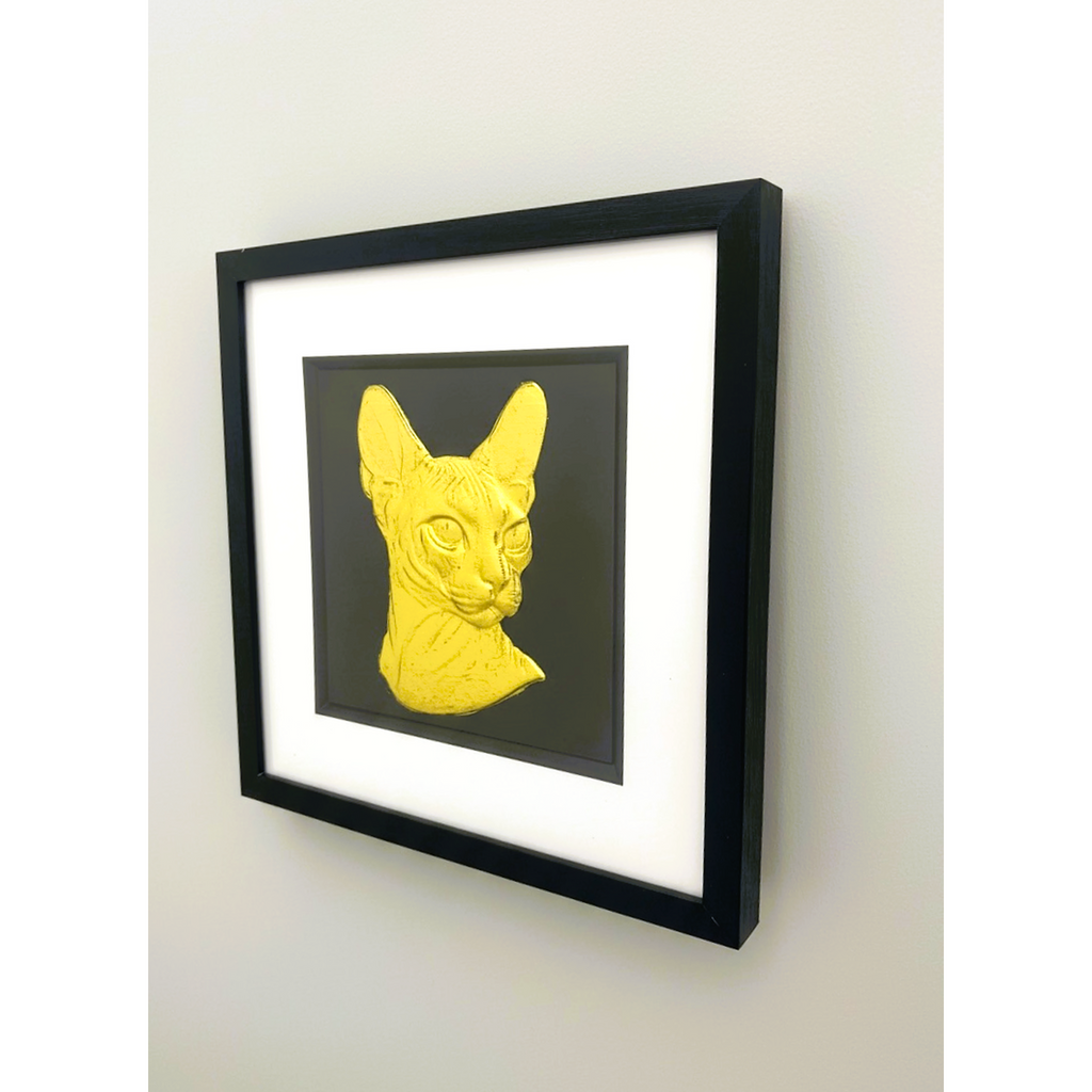 Sphynx cat gold leaf framed wall art displayed on wall with black frame and white mount