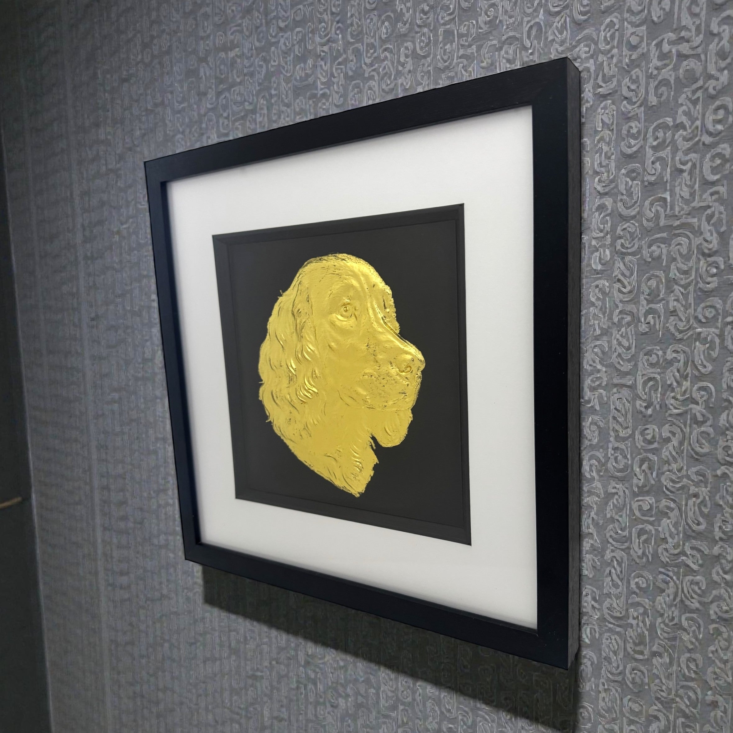 Gold springer spaniel wall art framed and mounted on a dark grey wall at an angle showing frame depth
