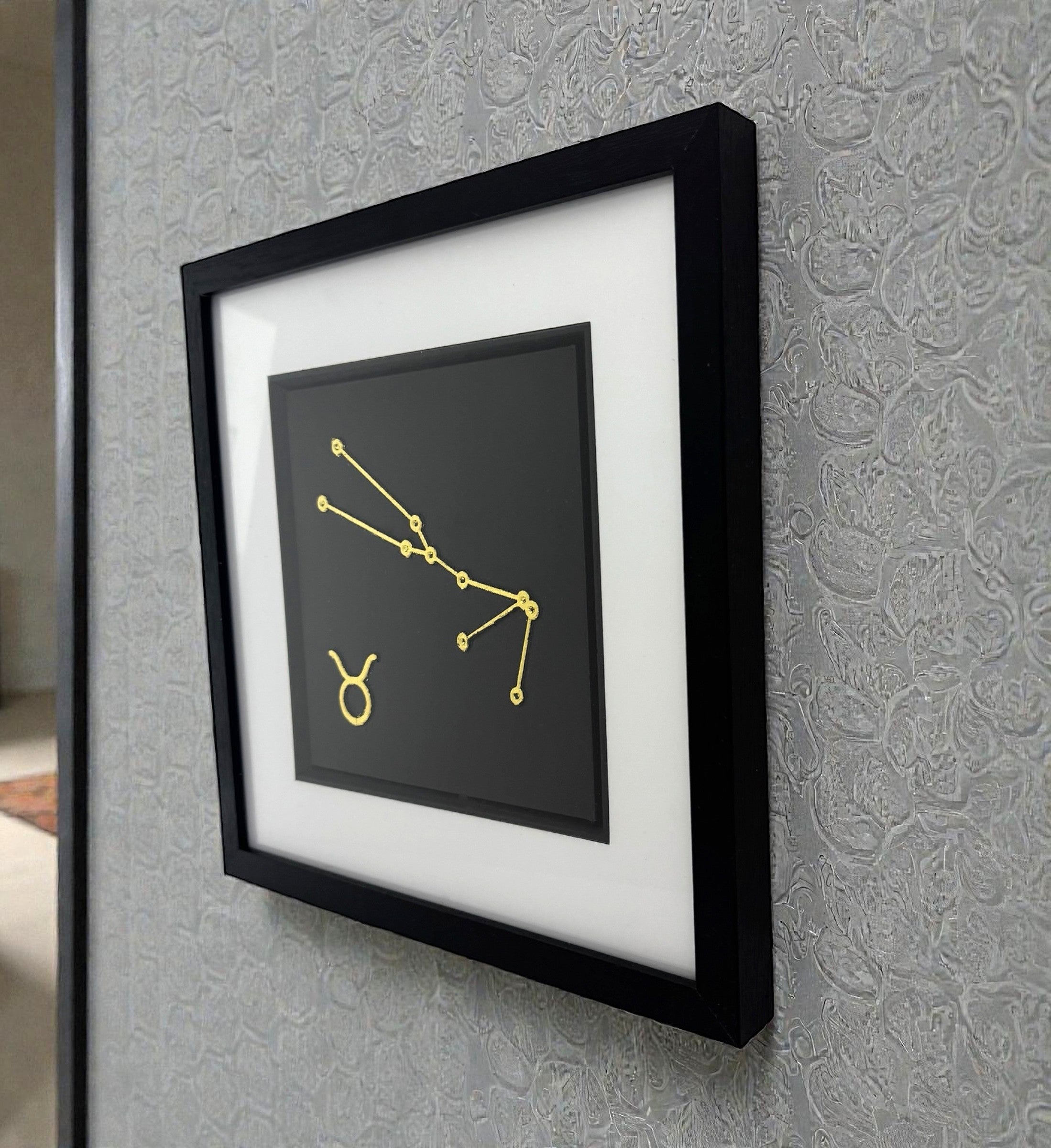 Taurus constellation wall art displayed on wall in black frame