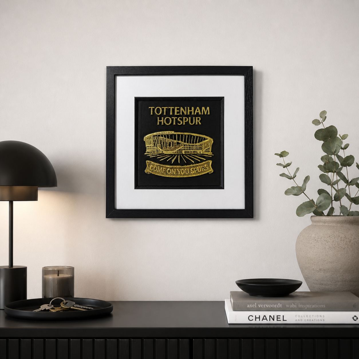 Lifestyle photo of Tottenham Hotspur wall art displayed on a neutral wall above a dark console table with modern decor.