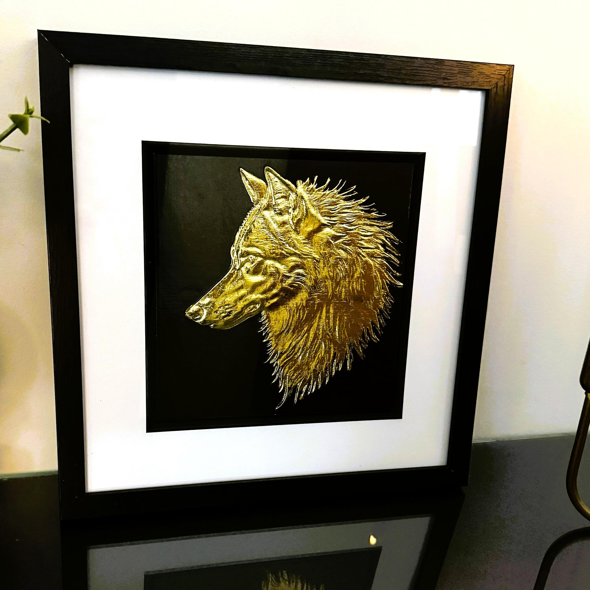 Gold wolf head wall art framed in black with white mount on black background