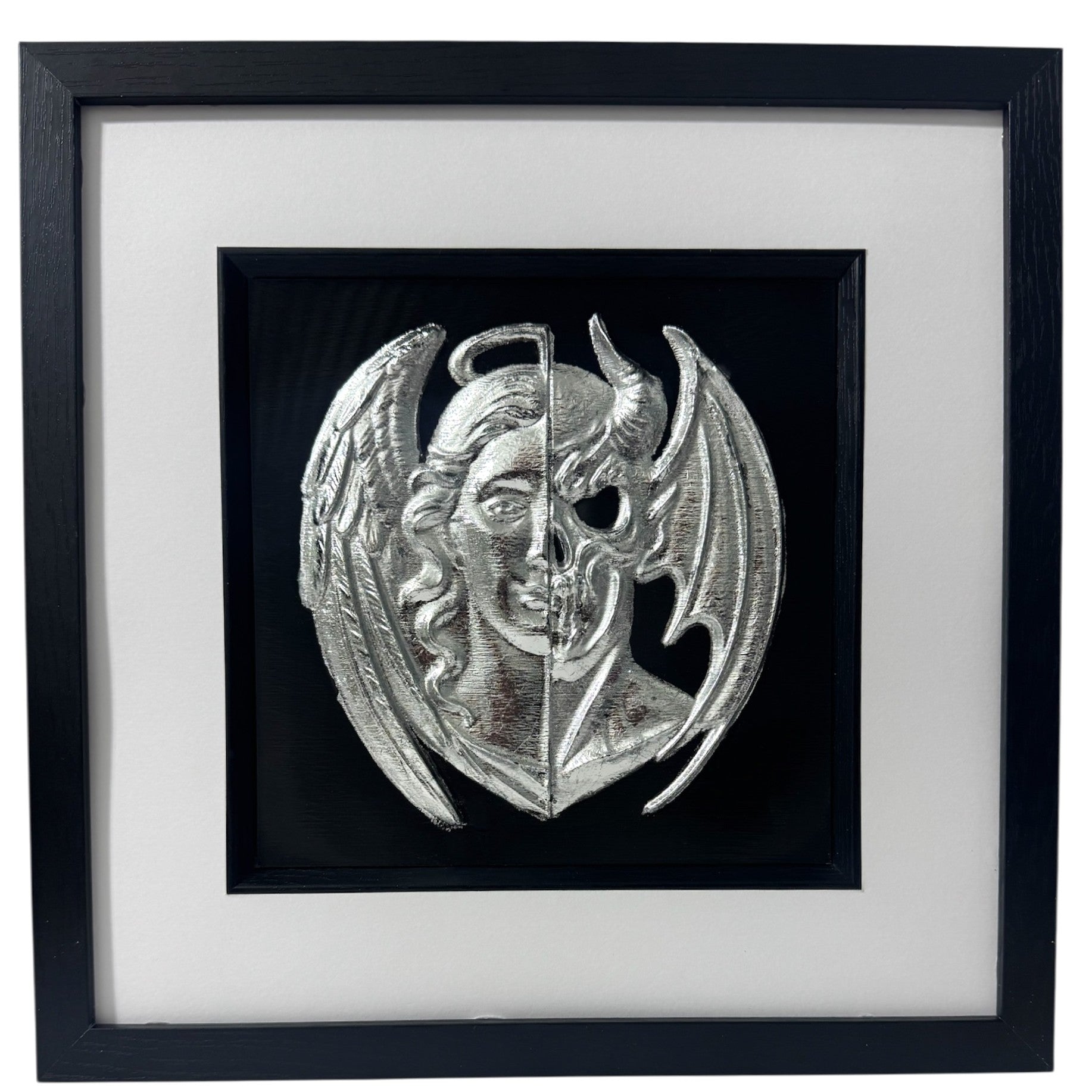 Angel and demon face wall art framed in black with silver leaf relief