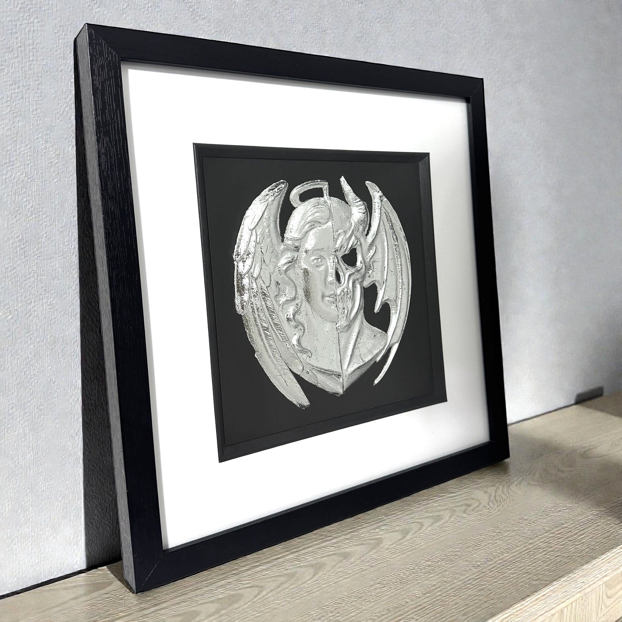 Side view of angel and demon wall art showing frame depth