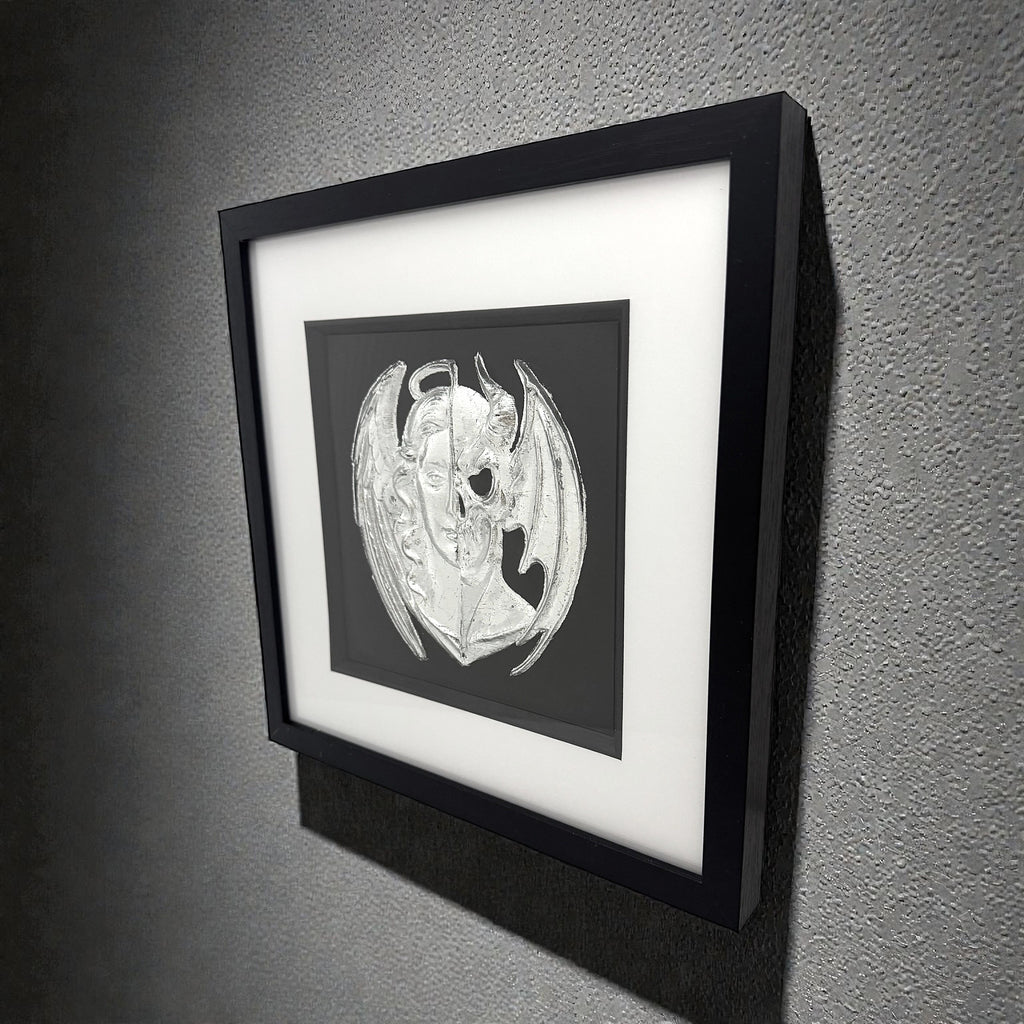 Framed angel and demon wall art displayed on wall