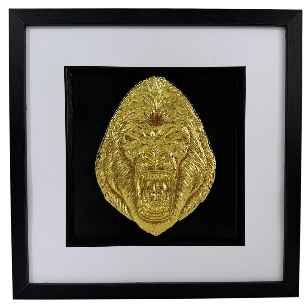 Straight-on gorilla artwork in Gold finish, raised gorilla face relief, black central backing, black inner surround, wide white mount and black square box frame.